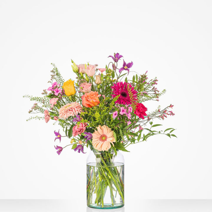 Middelgroot boeket met kleurrijke bloemen zoals gerbera’s, rozen, en chrysanten in een glazen vaas, geschikt voor felicitatiegelegenheden.