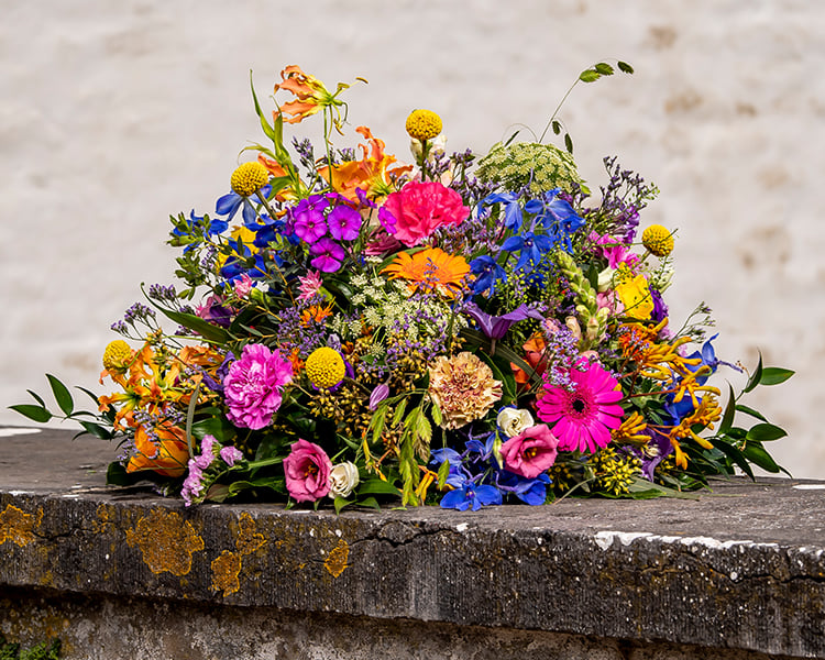 Biedermeier rouwstuk met kleurrijke bloemen, gemaakt door Buurtbloemist voor een stijlvol afscheid.
