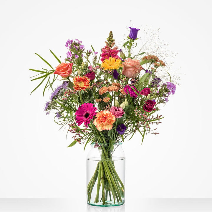 Groot veldboeket met roze, paarse, oranje en gele bloemen zoals gerbera’s, rozen en leeuwenbekjes