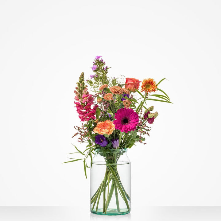 Klein boeket met kleurrijke bloemen in warme tinten, waaronder gerbera’s, rozen en leeuwenbekken