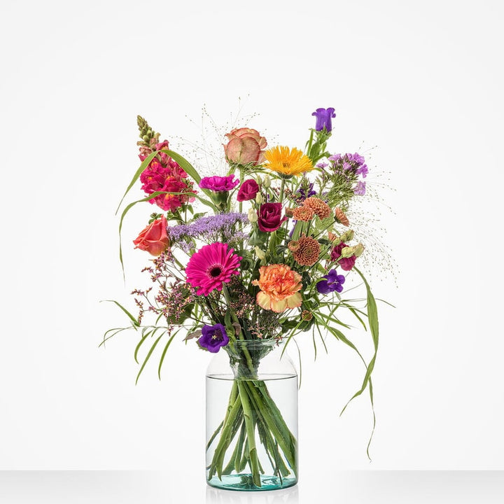 Middelgroot boeket met een mix van warme tinten, waaronder roze, oranje en paars, met bloemen zoals gerbera’s en rozen