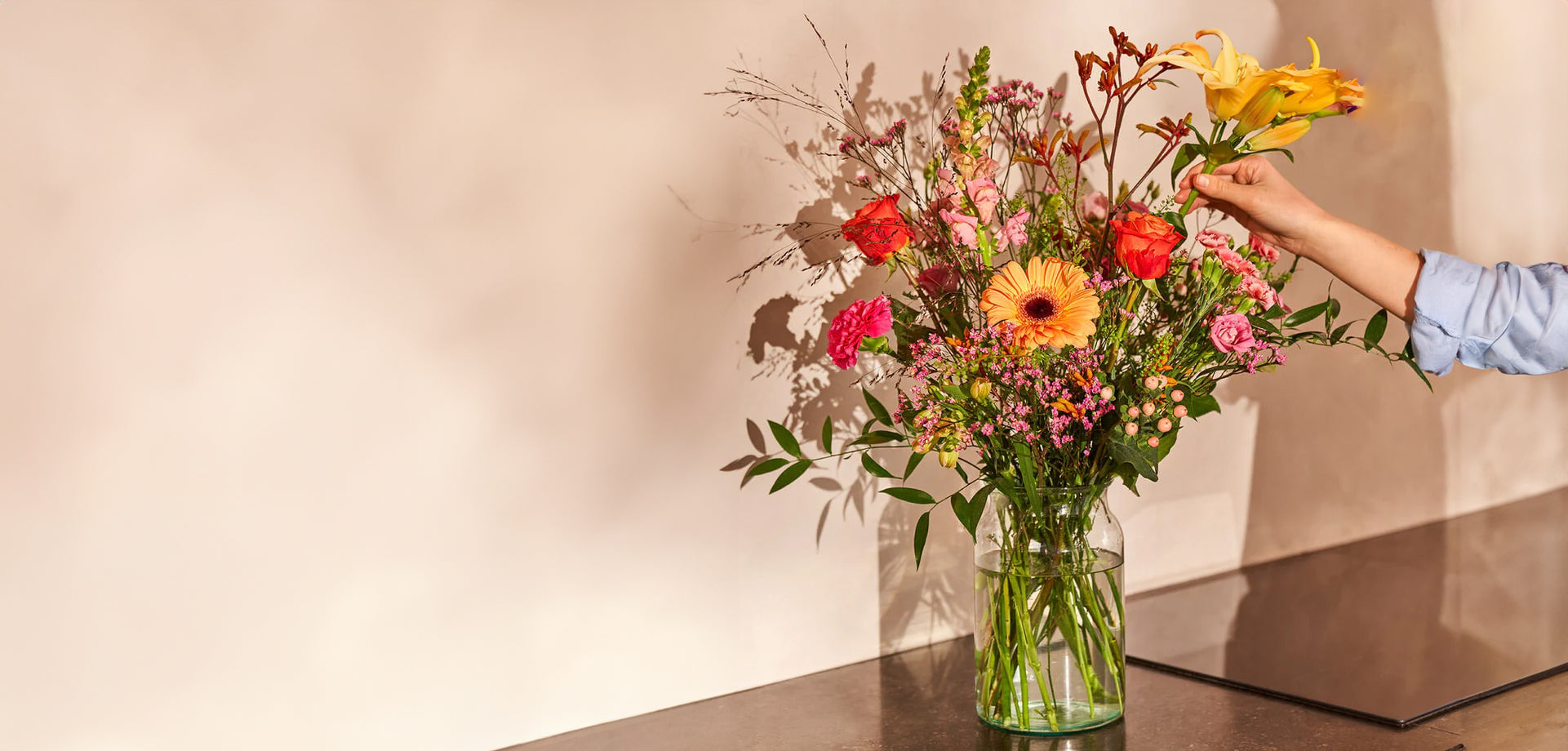 Sterkte boeket met kleurrijke bloemen in een glazen vaas, geschikt om medeleven te tonen.