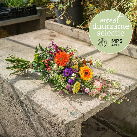Duurzaam kleurrijk rouwboeket met oranje gerbera's, paarse bloemen en diverse seizoensbloemen, liggend gebonden.