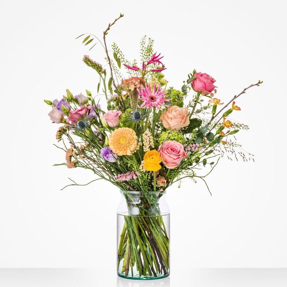 Klein boeket met pastel- en voorjaarstinten in een glazen vaas