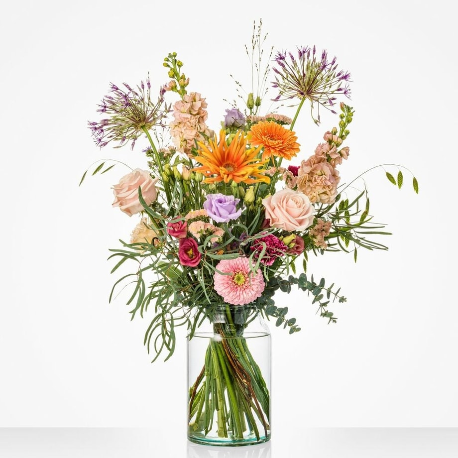 Groot veldboeket met vrolijke bloemen in tinten van oranje, lila, roze en zachtgeel, waaronder gerbera’s, rozen en alliums