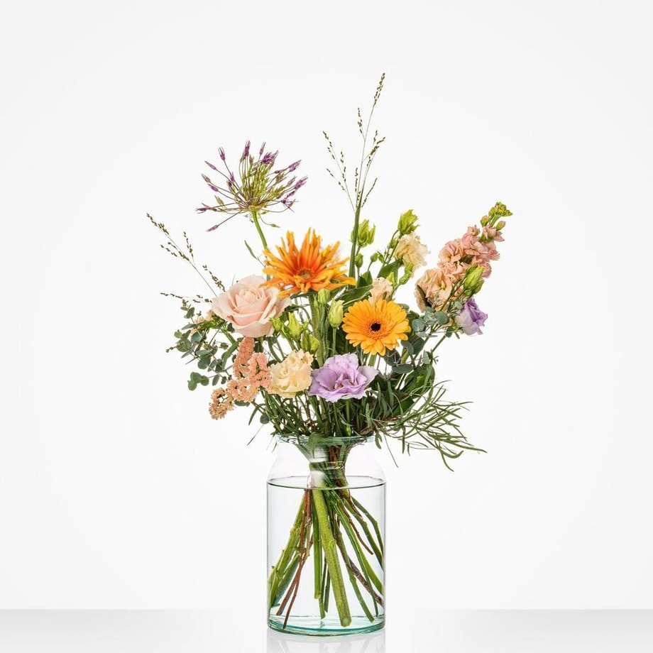 Klein boeket met zachte en vrolijke bloemenkleuren, waaronder oranje gerbera’s, lila lisianthus en rozen