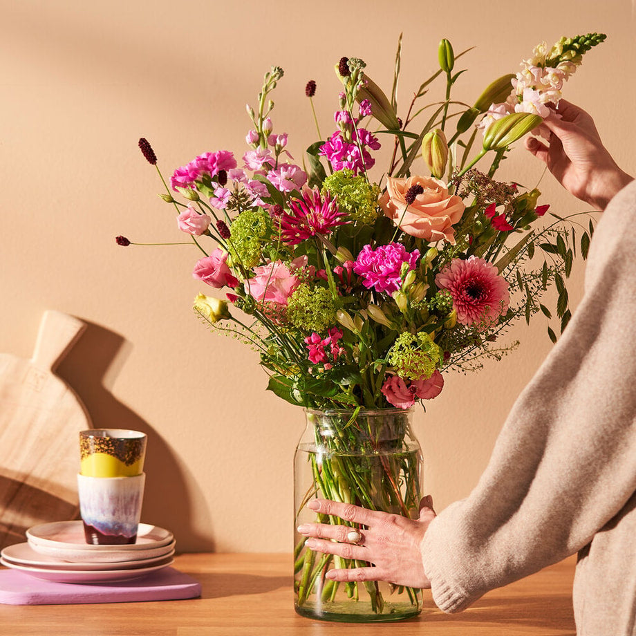 Lente boeket met roze bloemen op tafel in warme sfeervolle setting