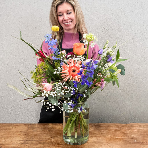 Bloemist met vrolijk lenteboeket vol kleurrijke bloemen