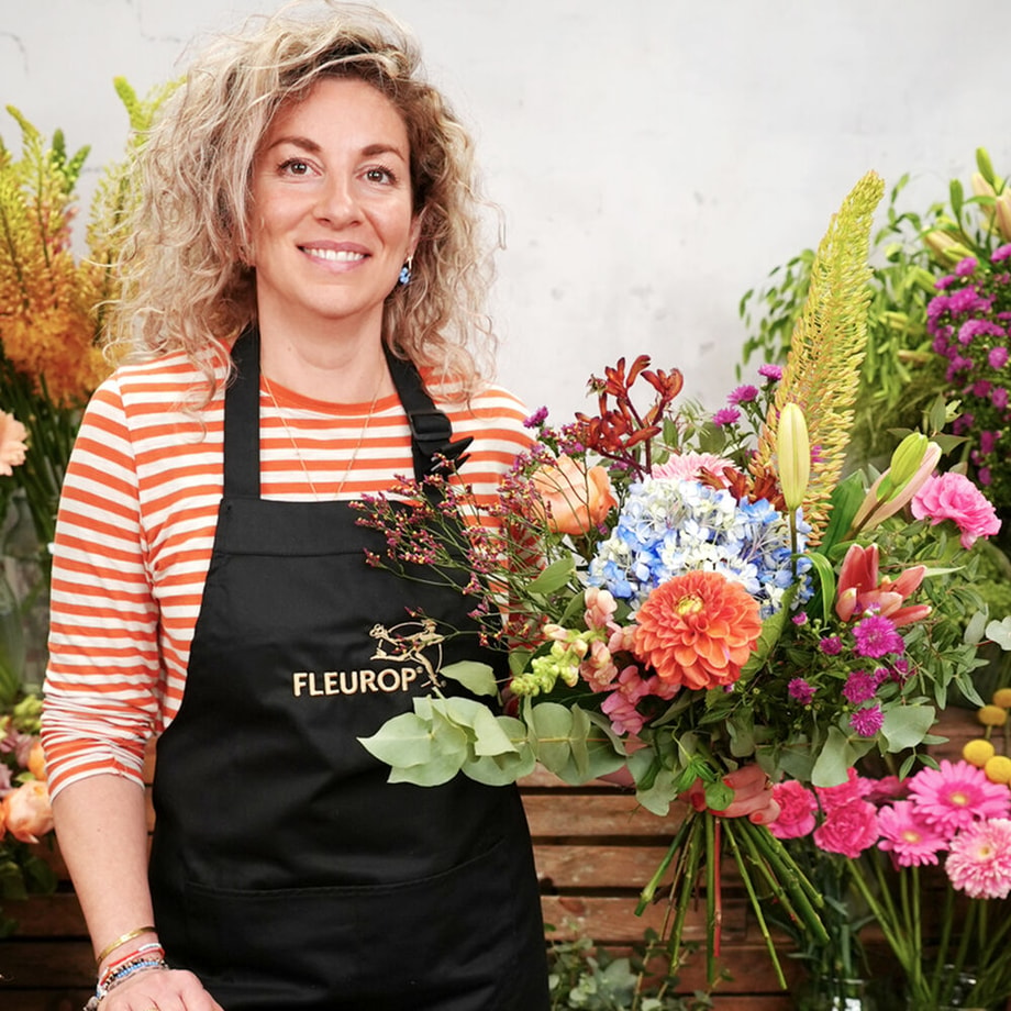 Bloemist met het maandboeket augustus, een arrangement van seizoensbloemen zoals hortensia’s, lelies en dahlia’s.