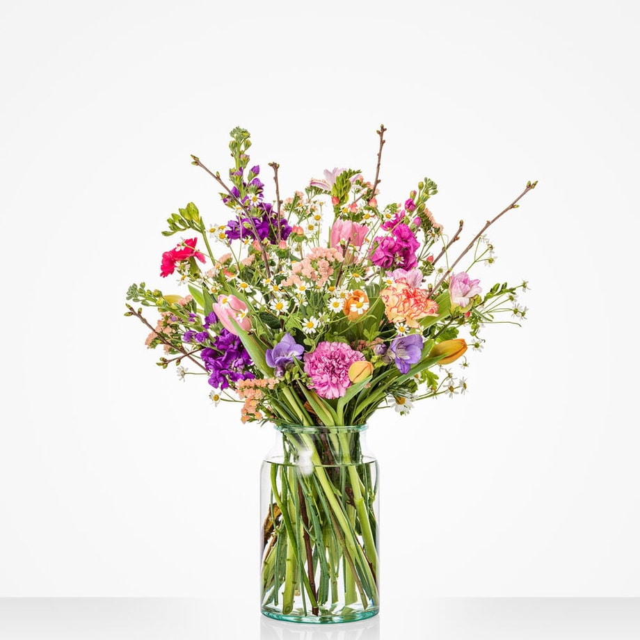 Rond boeket met voorjaarsbloemen als tulpen, violier en kamille.