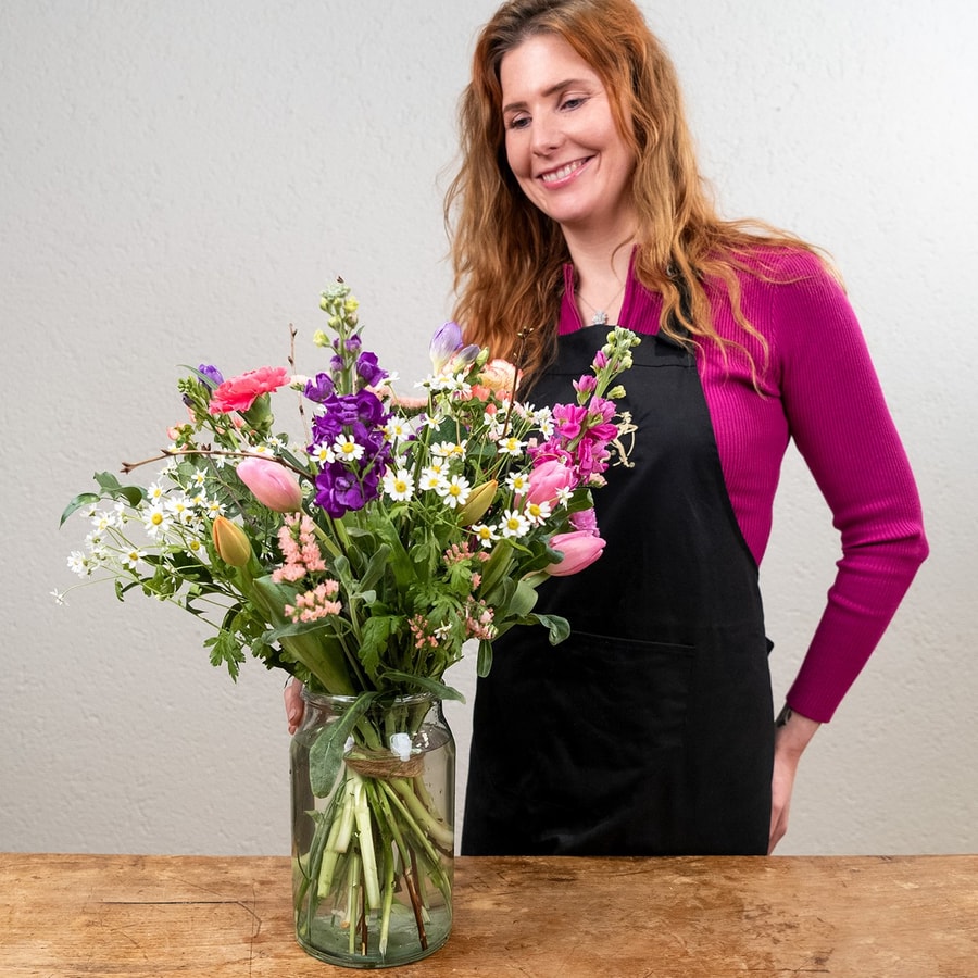 Voorjaarsboeket met tulpen, violier en kamille in glazen vaas.