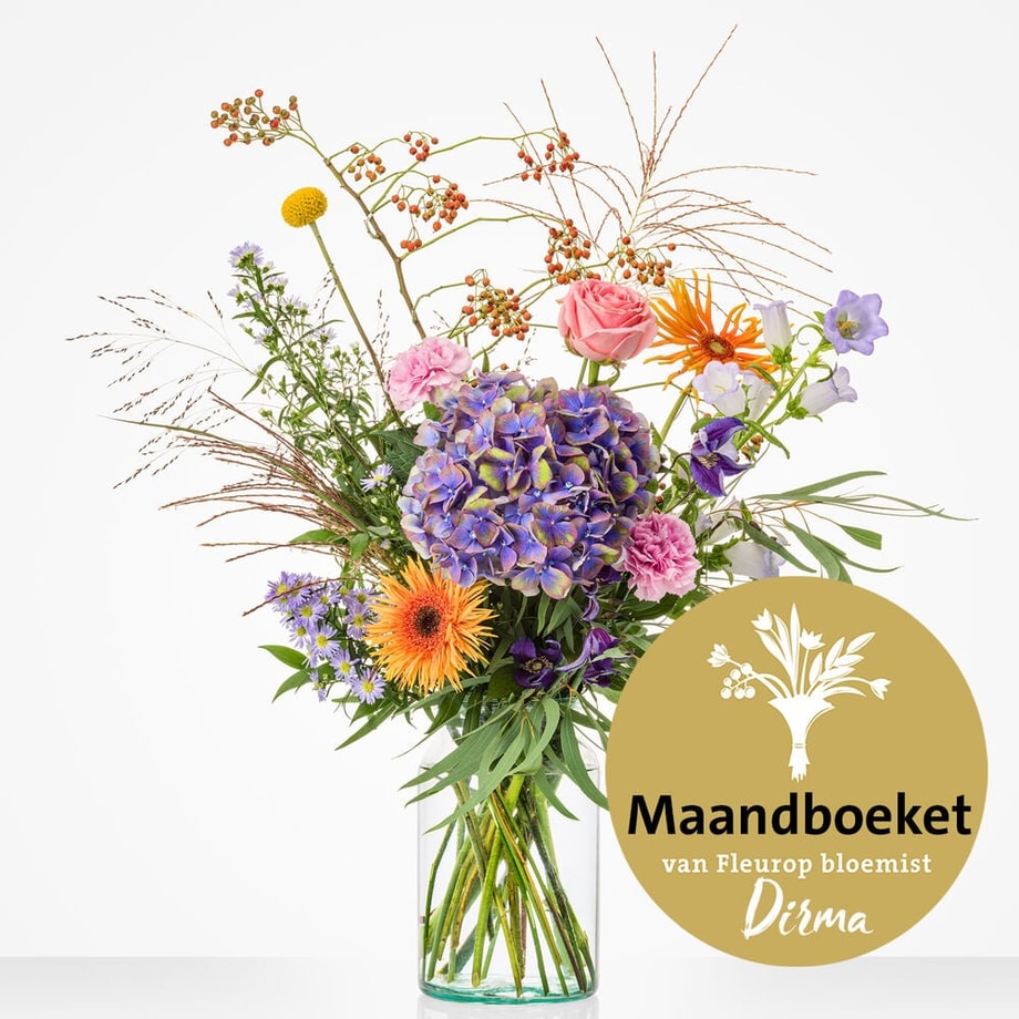Middelgroot boeket in een glazen vaas, met een mix van bloemen zoals roze rozen, paarse hortensia, oranje gerbera’s, roze anjers, paarse campanula, en groene bladeren.