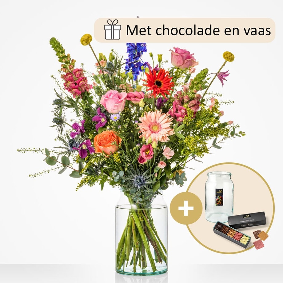 Groot boeket in een glazen vaas, met een mix van kleurrijke bloemen zoals oranje rozen, roze gerbera’s, blauwe ridderspoor en andere seizoensbloemen.