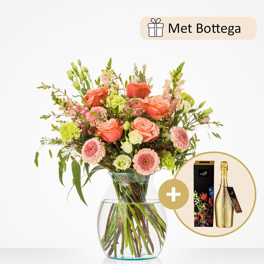 Middelgroot boeket in een glazen vaas, met oranje rozen, roze gerbera’s, groene bladeren, en andere bloemen, samen met een fles Bottega wijn.