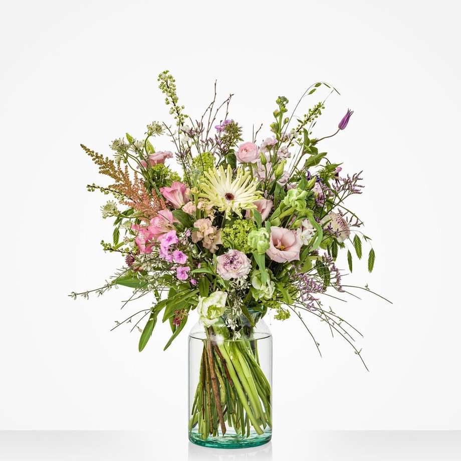 Voorjaarsboeket middelgroot met zachte tinten en luchtige styling in vaas