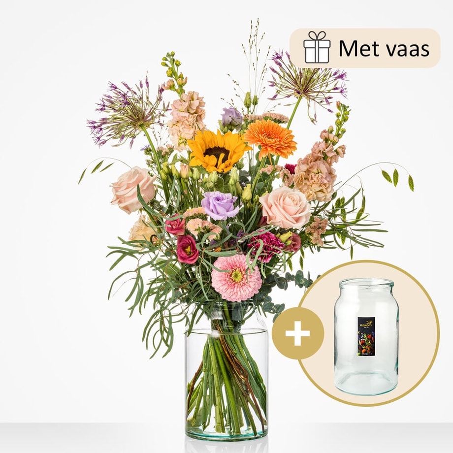 Groot bloemenboeket, gepresenteerd in een glazen vaas. Het boeket bevat zonnebloemen, rozen, gerbera’s, alliums en eucalyptus.