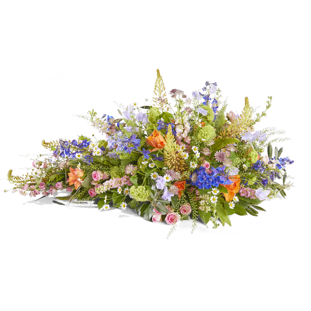 Liggend rouwstuk in veldtuin stijl met delphinium, rozen en seizoensbloemen