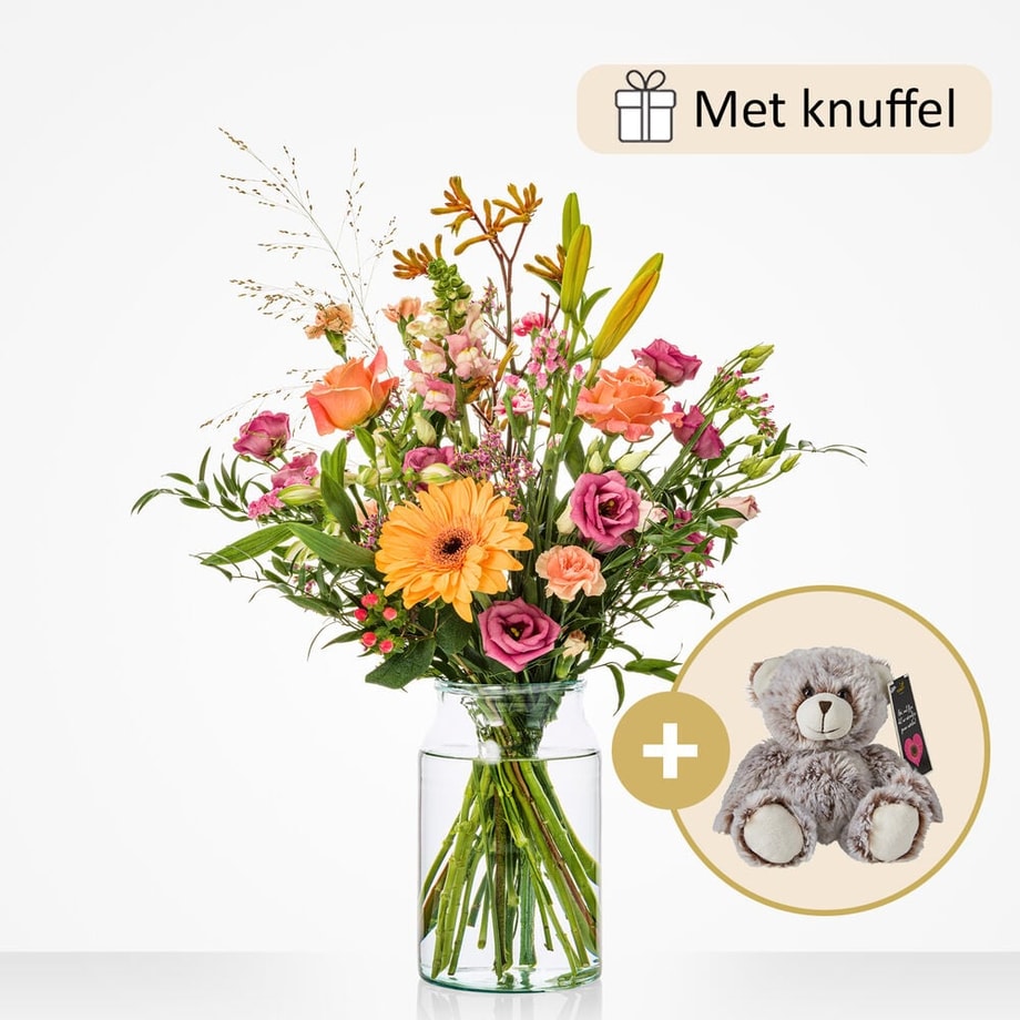 Klein boeket met een selectie van bloemen zoals oranje gerbera’s, roze rozen, lila bloemen, en gele lelies in een compacte glazen vaas, gepresenteerd met een knuffel.