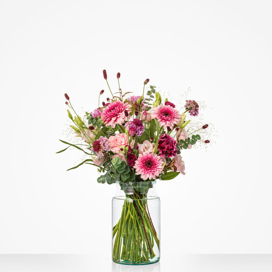Middelgroot boeket voor mama met roze, paarse en lila bloemen in een glazen vaas