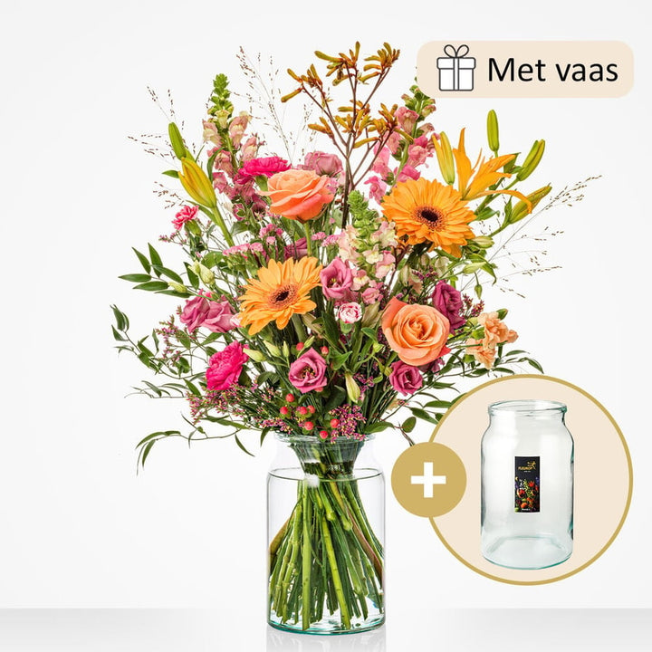 Groot boeket met een rijke mix van bloemen zoals oranje gerbera’s, roze rozen, lila eustoma’s, en gele lelies, gepresenteerd in een grote glazen vaas.