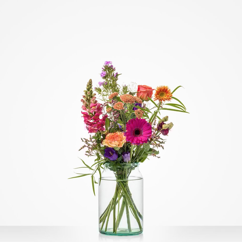 Klein boeket met kleurrijke bloemen in warme tinten, waaronder gerbera’s, rozen en leeuwenbekken