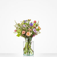 Klein winterboeket met roze rozen, paarse lisianthus en pastelbloemen in glazen vaas.