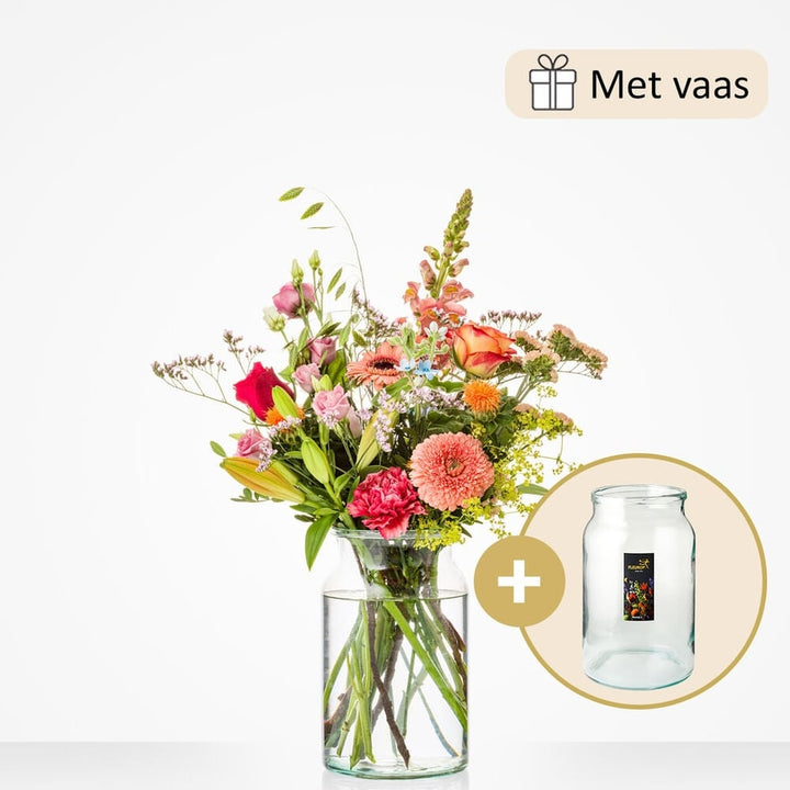 Klein boeket met zomerse bloemen zoals roze rozen, rode anjers, gerbera’s, leeuwenbekjes en gele lelies, gepresenteerd in een glazen vaas.