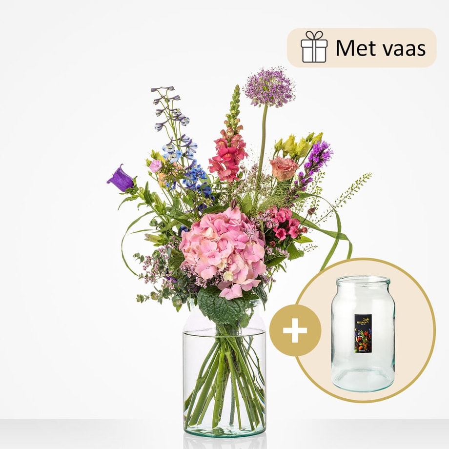 Klein boeket met een selectie van bloemen zoals roze hortensia’s, riddersporen, leeuwenbekjes, en paarse bloemen, geleverd met een glazen vaas.