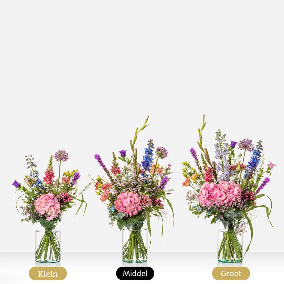 Drie boeketten in verschillende maten: klein, middel, en groot. Elk boeket bevat een variatie van bloemen zoals roze hortensia’s, riddersporen, leeuwenbekjes, en paarse bloemen, gepresenteerd in een glazen vaas.