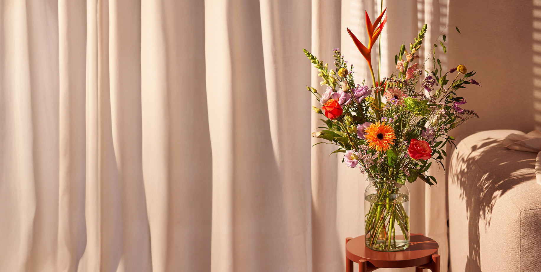 Gefeliciteerd boeket met kleurrijke bloemen op een tafeltje, sfeervol verlicht door zonnestralen.